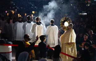 Father Boniface Hicks, O.S.B., a sought-after spiritual director and retreat master, processes the massive golden monstrance containing the Eucharist into the midst of the assembled crowd in Lucas Oil Stadium. Credit: Jonah McKeown/CNA