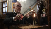 The Latin patriarch of Jerusalem, Cardinal Pierbattista Pizzaballa, lights a candle in the Orthodox Church of St. Porphyrius in Gaza during his visit there on Dec. 22, 2024.