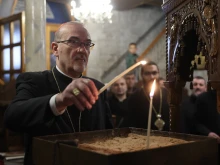 The Latin patriarch of Jerusalem, Cardinal Pierbattista Pizzaballa, lights a candle in the Orthodox Church of St. Porphyrius in Gaza during his visit there on Dec. 22, 2024.