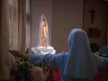 A Japanese nun holds her arms out as she prays at a chapel in her convent in Nagasaki, Japan.