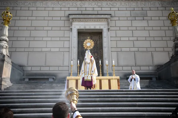 Bishop Andrew Cozzens holds the Eucharist aloft over the faithful while standing on the Indiana War Memorial. Credit: Jeffrey Bruno