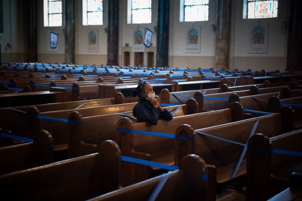 Žena se moli sama tijekom zaključavanja Coid-19 u crkvi Gospe od Anđela u Brooklynu, New York. Kredit: Jeffrey Bruno