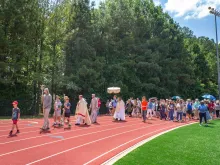 Pilgrims on the Juan Diego route of the National Eucharistic Pilgrimage process on a track in Georgia.