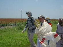 Charlie McCullough, in grey hoodie, walks with the Eucharistic procession through southern Texas.
