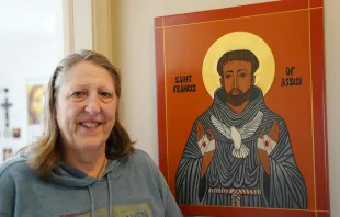 Kathleen Bordo Crombie stands next to an icon of St. Francis of Assisi, dedicated to her late husband, Robyn. The Church of the Divine Child in Dearborn, Michigan, parishioner took up iconography after taking a class at the Sacred Art Institute of St. Edmund’s Retreat Center on Enders Island in Mystic, Connecticut, where she learned iconography is rooted in depicting the image of God. Credit: Daniel Meloy/Detroit Catholic