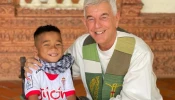 Father “Kike” Figaredo with one of the disabled children he helps in Cambodia.