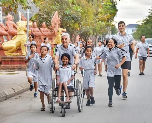 Father Kike Figaredo and others accompany a disabled child. Credit: Courtesy of Father Kike Figaredo