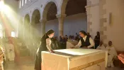 The Sisters of St. Joseph of the Apparition cover the altar, just dedicated by the cardinal. The covering of the altar signifies that it is both the place of the Eucharistic sacrifice and the Lord’s table.