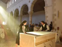 The Sisters of St. Joseph of the Apparition cover the altar, just dedicated by the cardinal. The covering of the altar signifies that it is both the place of the Eucharistic sacrifice and the Lord’s table.