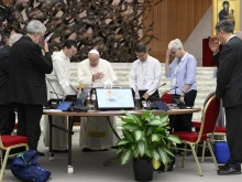 Pope Francis prays with members of the Synod on Synodality during one of its meetings in the Vatican's Paul VI Hall on the morning of Oct. 12, 2024.