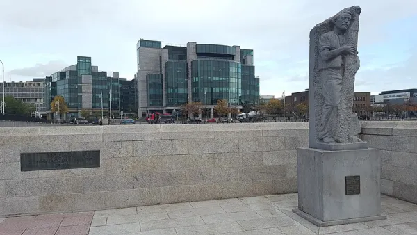 A statue of Matt Talbot at Matt Talbot Bridge in Dublin with Dublin’s financial district in the background. Credit: Cograng, CC BY-SA 4.0, via Wikimedia Commons