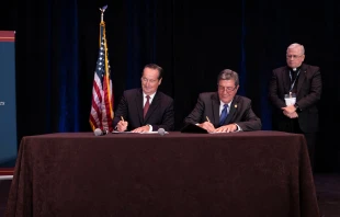 Benedictine College President Stephen D. Minnis and Catholic Healthcare International founder and President Jere D. Palazzolo sign a Collaborative Affiliation Agreement Sept. 8, 2022 in Denver, Colorado, beginning the process of establishing an independent medical school on the Benedictine campus, as CHI board member Fr. Timothy Nelson, MD, looks on. Benedictine College