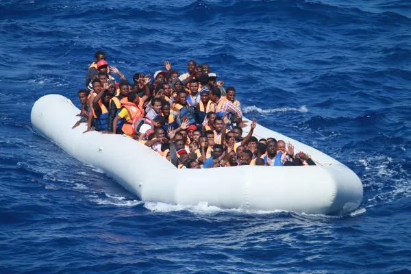 Migranti na brodu na napuhavanje u Sredozemnom moru približavaju se razaraču s navođenim projektilima USS Carney 2013. Carney je opskrbio hranu i vodu migrantima na brodu prije nego što se dogovorio s obližnjim trgovačkim brodom kako bi ih odveo na sigurno. Zasluge: Zapovjednik, američke pomorske snage Europa-Afrika/američka 6. flota, javno vlasništvo, putem Wikimedia Commons