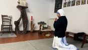 A sister kneels before the tabernacle after inviting a group of women donating Christmas gifts to pray in the Missionaries of Charity house in Rome.