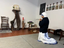 A sister kneels before the tabernacle after inviting a group of women donating Christmas gifts to pray in the Missionaries of Charity house in Rome.