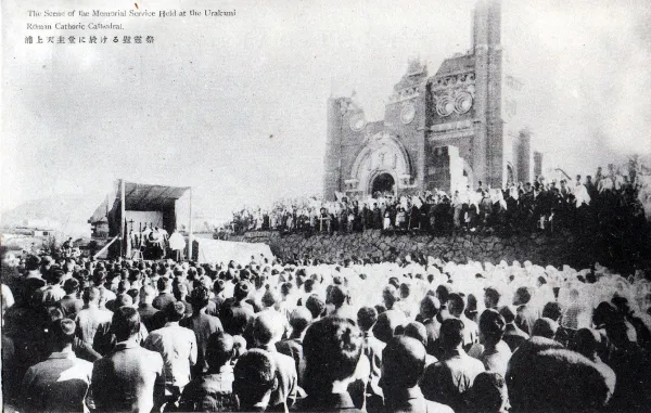 Postcard of the memorial service held at the Urakami Roman Catholic Cathedral, November 23, 1945. (The Pictorial Post-Cards Regarding the War Calamities, Suffered on August 9, 1945). Credit: Nagasaki City Office (長崎市役所), Public domain, via Wikimedia Commons