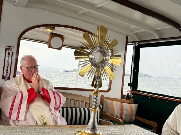Kardinal Timothy Dolan iz New Yorka moli se prije euharistije dok se ona prevozi brodom pokraj Kipa slobode.  Zasluge: Jeffrey Bruno/CNA