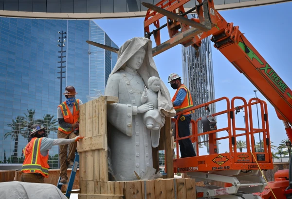 Crews carefully cut away at the box holding Christ Cathedral’s Our Lady of La Vang statue on June 2, 2021. It took three days to install the Italian marble statue, which weighs an estimated 16,000 pounds and, together with a cloud and base, is 18 feet tall. Credit: Steven Georges / Diocese of Orange