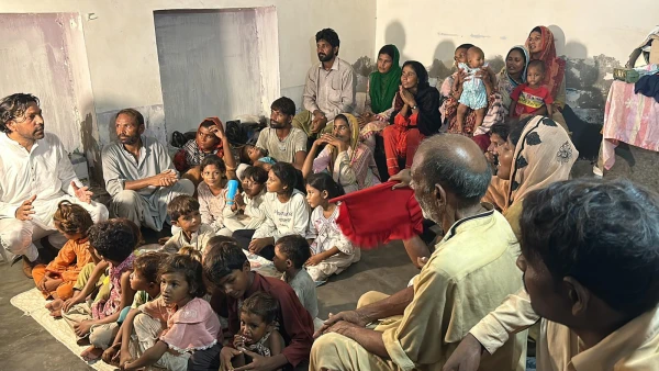 A local volunteer (left in photo) speaks to an extended family of Pakistani Christians liberated from slavery. Credit: Courtesy of Order of St. Elijah