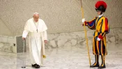 Pope Francis walks with a cane as he enters the Vatican's Pope Paul VI Hall to hold his weekly general audience on Aug. 21, 2024.