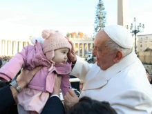 Pope Francis blessing a baby during a general audience.