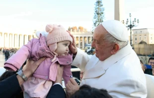 Pope Francis blessing a baby during a general audience. Credit: Vatican Media