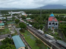 An aerial view shows a long line of trucks stranded along a flooded highway caused by heavy rains brought about by Tropical Storm Trami in Nabua town, Camarines Sur province, South of Manila, Philippines, on Oct. 23, 2024.