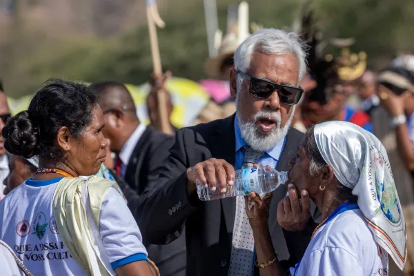 A woman drinks water amid high temperatures during Mass at the Esplanade of Taci Tolu in Dili, Timor-Leste, Tuesday, Sept. 10, 2024. Credit: Daniel Ibáñez/CNA