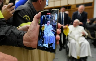 A person takes a photo of Pope Francis on a cell phone during a papal audience on Dec. 10, 2022. Vatican Media