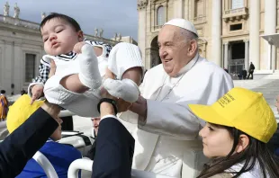 Pope Francis receives a baby for a blessing as pilgrims gather in St. Peter’s Square for the pope’s general audience on Wednesday, April 10, 2024. Credit: Vatican Media