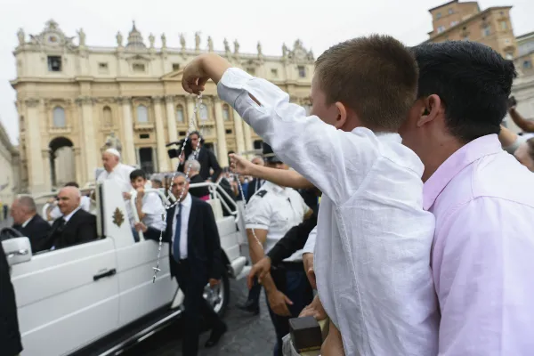 A boy holds up a rosary as Pope Francis passes by in St. Peter’s Square during the pope’s general audience on Wednesday, June 19, 2024. Credit: Vatican Media