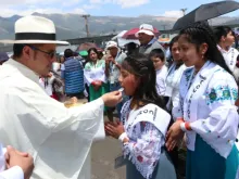 A priest gives Communion to children at the 53rd International Eucharistic Congress in Quito, Ecuador, on Sunday, Sept. 8, 2024.