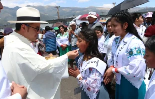 A priest gives Communion to children at the 53rd International Eucharistic Congress in Quito, Ecuador, on Sunday, Sept. 8, 2024. Credit: Eduardo Berdejo/EWTN News