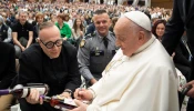 Pope Francis signs two bottles of bourbon presented to him by Father Jim Sichko at the Vatican on May 1, 2024.