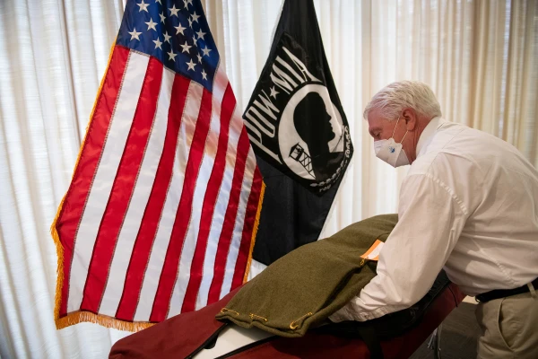 Ray Kapaun receives the remains of his uncle, Father Emil Kapaun, and places them on the gurney to transport him out of the Defense POW/MIA Accounting Agency in Hawaii. Credit: Photo courtesy of Ray Kapaun