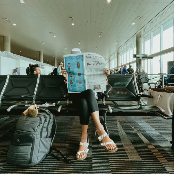 Savannah Dudzik sits in the airport holding a newspaper sharing the news that Roe v. Wade had been overturned on June 24, 2022. Credit: Photo courtesy of Savannah Dudzik