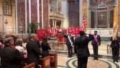 The faithful stand at attention for the national anthem at the archdiocesan Red Mass at the Cathedral of St. Matthew the Apostle, Sunday, Oct. 6, 2024.