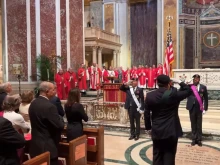 The faithful stand at attention for the national anthem at the archdiocesan Red Mass at the Cathedral of St. Matthew the Apostle, Sunday, Oct. 6, 2024.