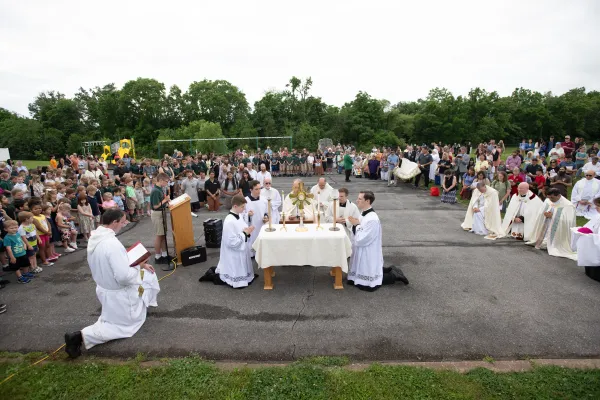 Svećenici pripremaju euharistiju za klanjanje na školskoj ploči.  Zasluge: Jeffrey Bruno