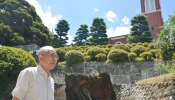 Catholic Shigemi Fukahori stands in front of the former bell tower of the Urakami Cathedral in Nagasaki, Nagasaki Prefecture, on July 17, 2013.