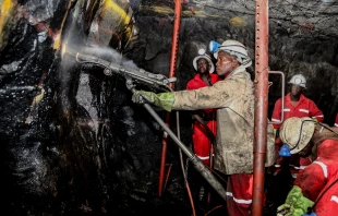 South African platinum and chrome miners drilling holes in rock for blasting. Shutterstock