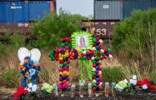 Texans brought prayer candles, bottles of water, and religious icons to a makeshift memorial at the site where 46 migrants were declared dead in San Antonio, Texas, in June 2022. Credit: Shutterstock