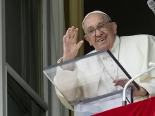 Pope Francis waves from a window of the Apostolic Palace at the crowds gathered in St. Peter's Square for his weekly Angelus address on Sunday, Sept. 22, 2024.