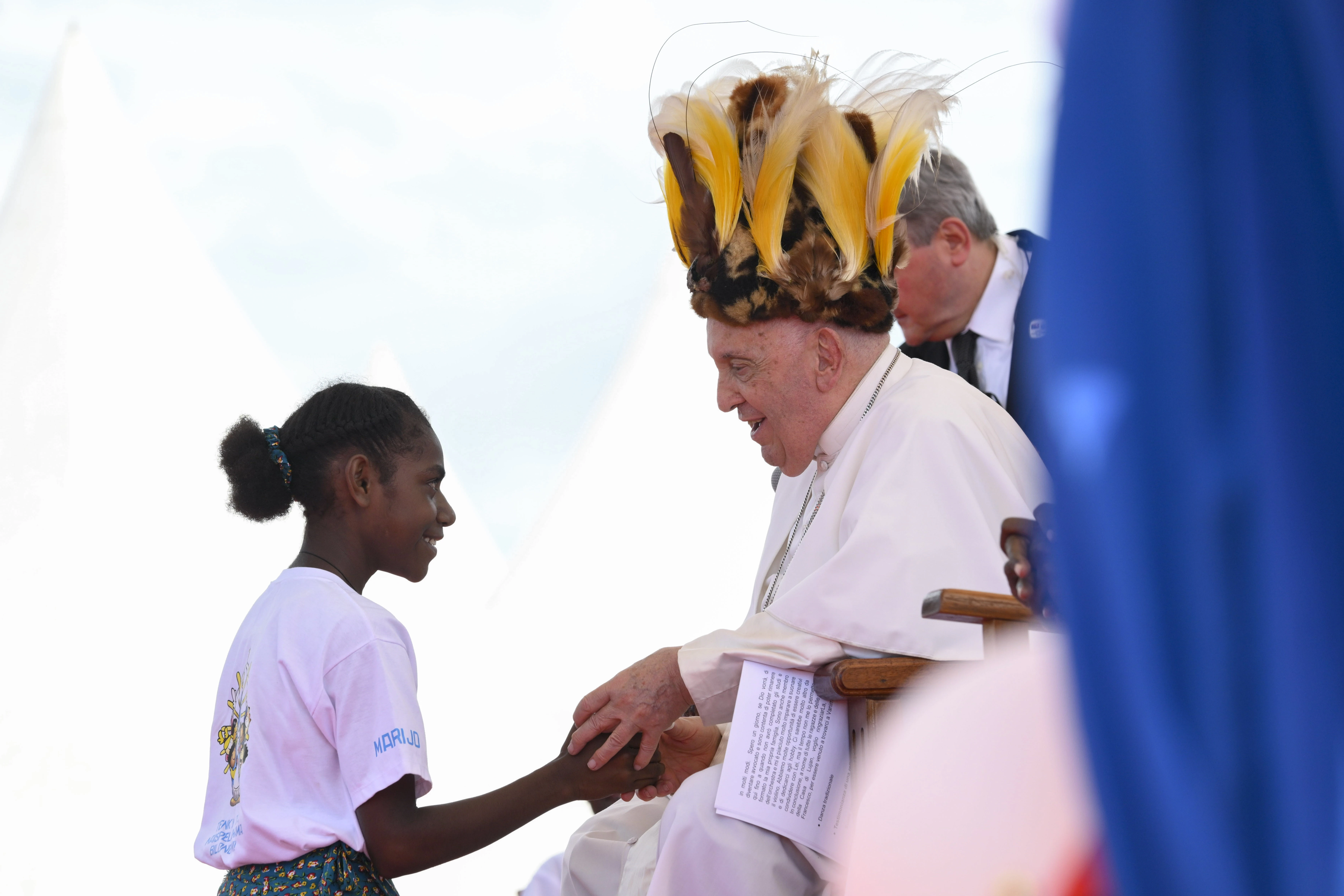 Pope Francis wears a traditional head dress as greets a young girl in Vanimo, Papua New Guinea, Sept. 8, 2024.?w=200&h=150