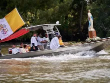 The Fête-Dieu du Teche, an annual procession in the bayou organized by the Community of Jesus Crucified in 2023. This boat carries a state of the Assumption, following a boat carrying the Blessed Sacrament.