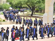 Graduates process across the historic St. Mary’s University campus in San Antonio toward their commencement ceremony in 2018.