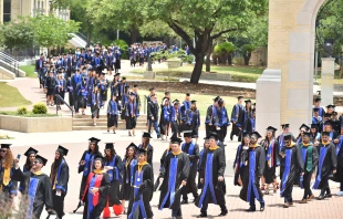 Graduates process across the historic St. Mary’s University campus in San Antonio toward their commencement ceremony in 2018. Credit: Robin Jerstad