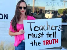 Jessica Tapia displays a sign outside the Garden Grove Unified School District board meeting on behalf of the Teachers Don’t Lie program.