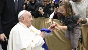 During his audience with Italian Catholic educators, Pope Francis interacts with a young girl at the Paul VI Audience Hall at the Vatican on Jan. 4, 2025.