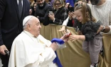 During his audience with Italian Catholic educators, Pope Francis interacts with a young girl at the Paul VI Audience Hall at the Vatican on Jan. 4, 2025.